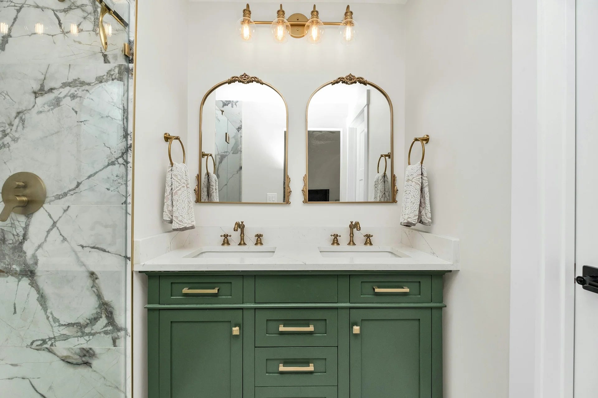 Bathroom with green vanity, double sink, and gold fixtures. Gallery - Quality Home Distribution