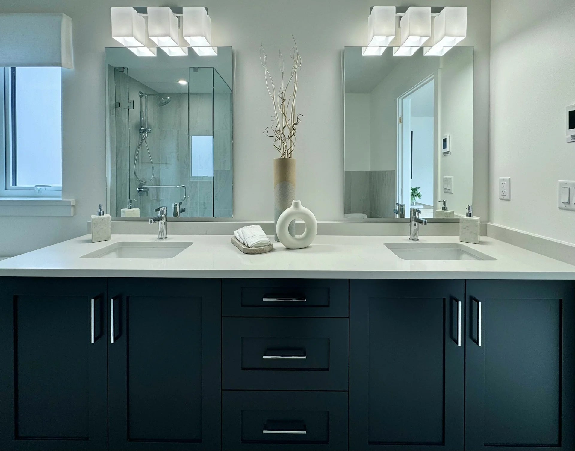 Modern bathroom with double sink vanity, mirrors, and decorative elements. Gallery - Quality Home Distribution